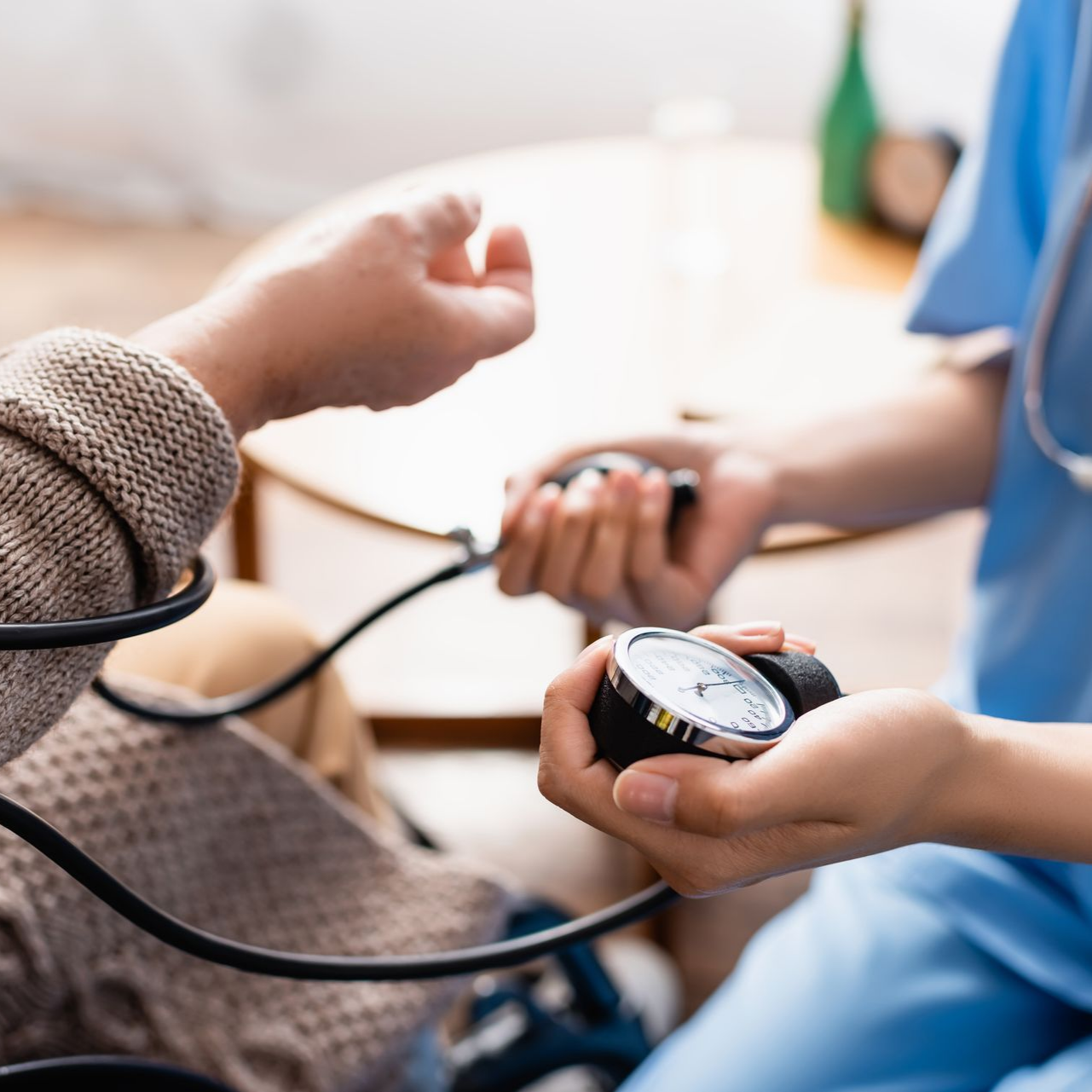 Un professionnel de santé prend la tension artérielle d'un patient à l'aide d'un tensiomètre.