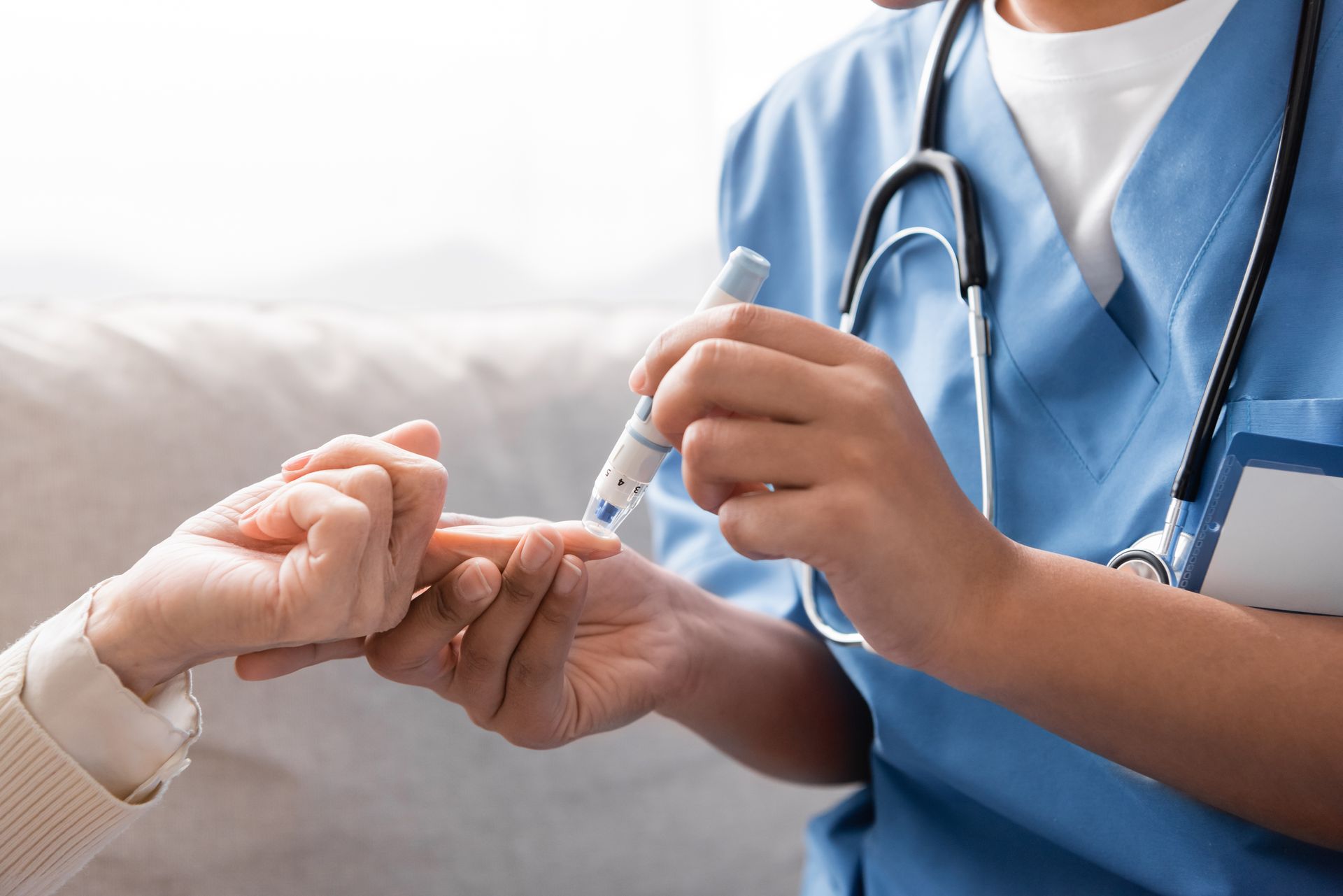 Un professionnel de santé mesure la glycémie d'un patient à l'aide d'un stylo autopiqueur.