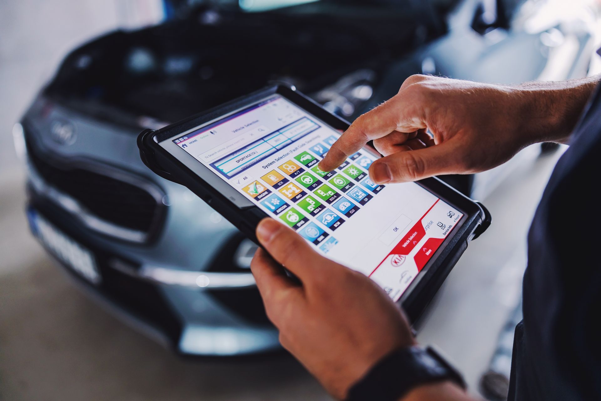 Un technicien équipé d'une tablette analysant les points de contrôle technique
