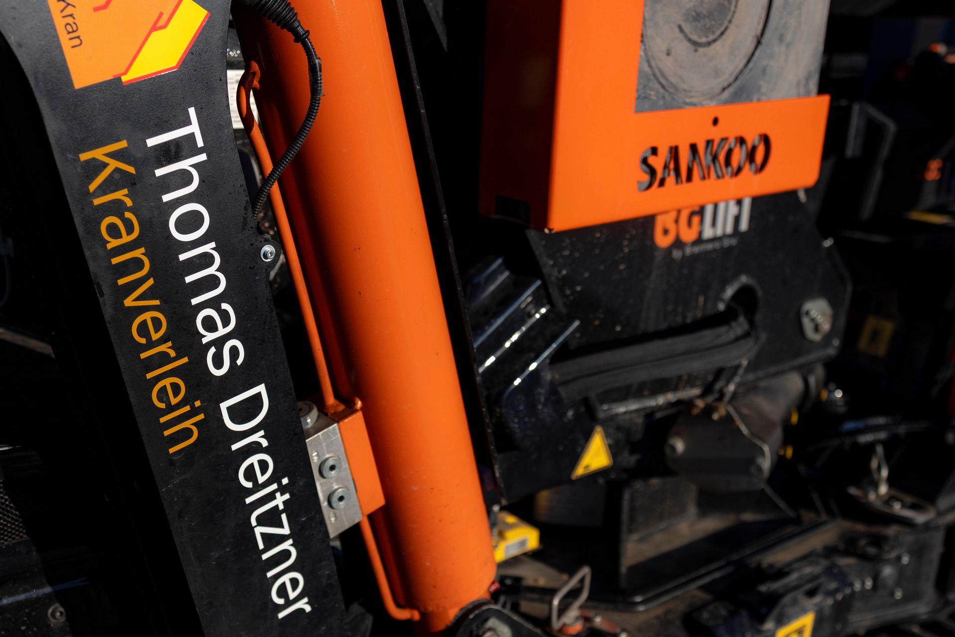 Oranger und schwarzer Kran mit der Aufschrift „Thomas Dreitzner Kranverleih“ und dem Etikett „SANDER 80 LIFT“.