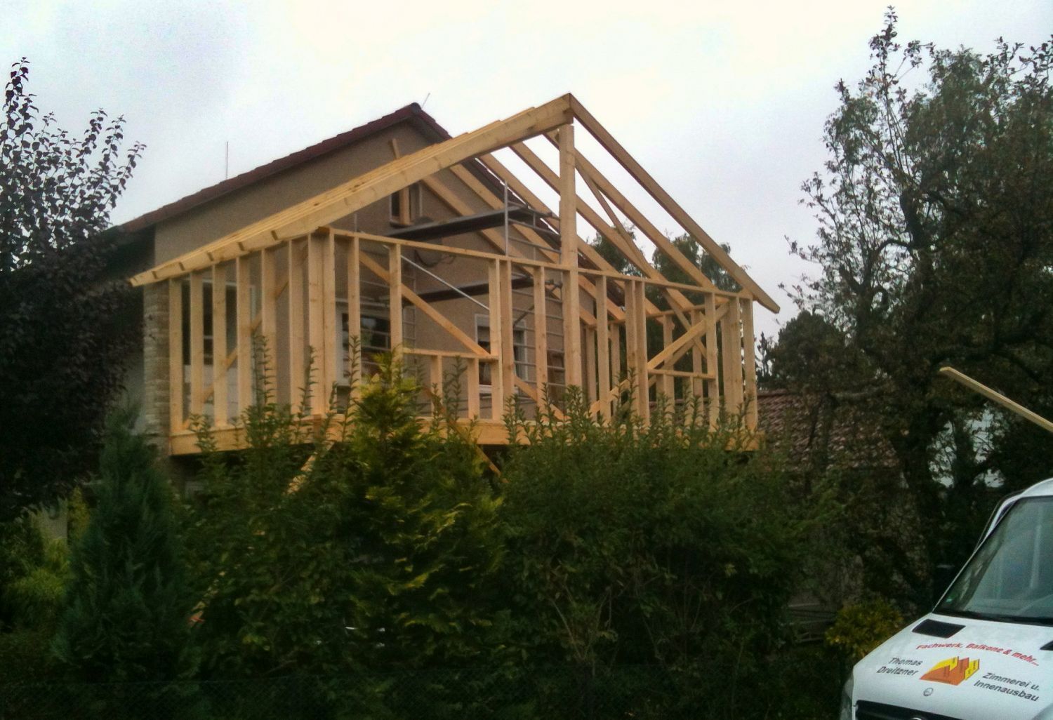 Holzgerüst eines Anbaus, der im Freien an ein Haus errichtet wird.