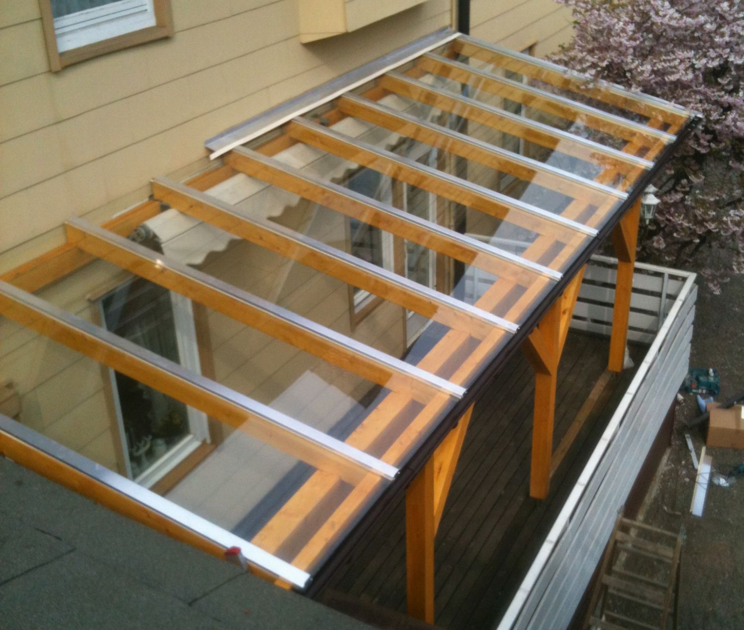 Holzterrasse mit transparentem Dach. Sonnige Lage im Freien.