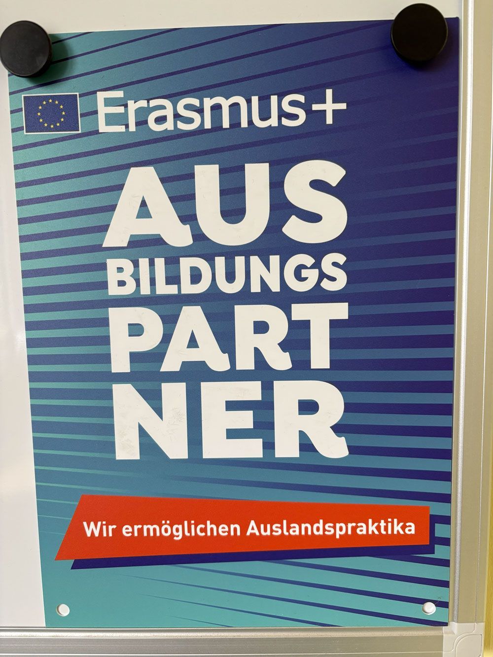 An Erasmus+ poster on a white board with the text 