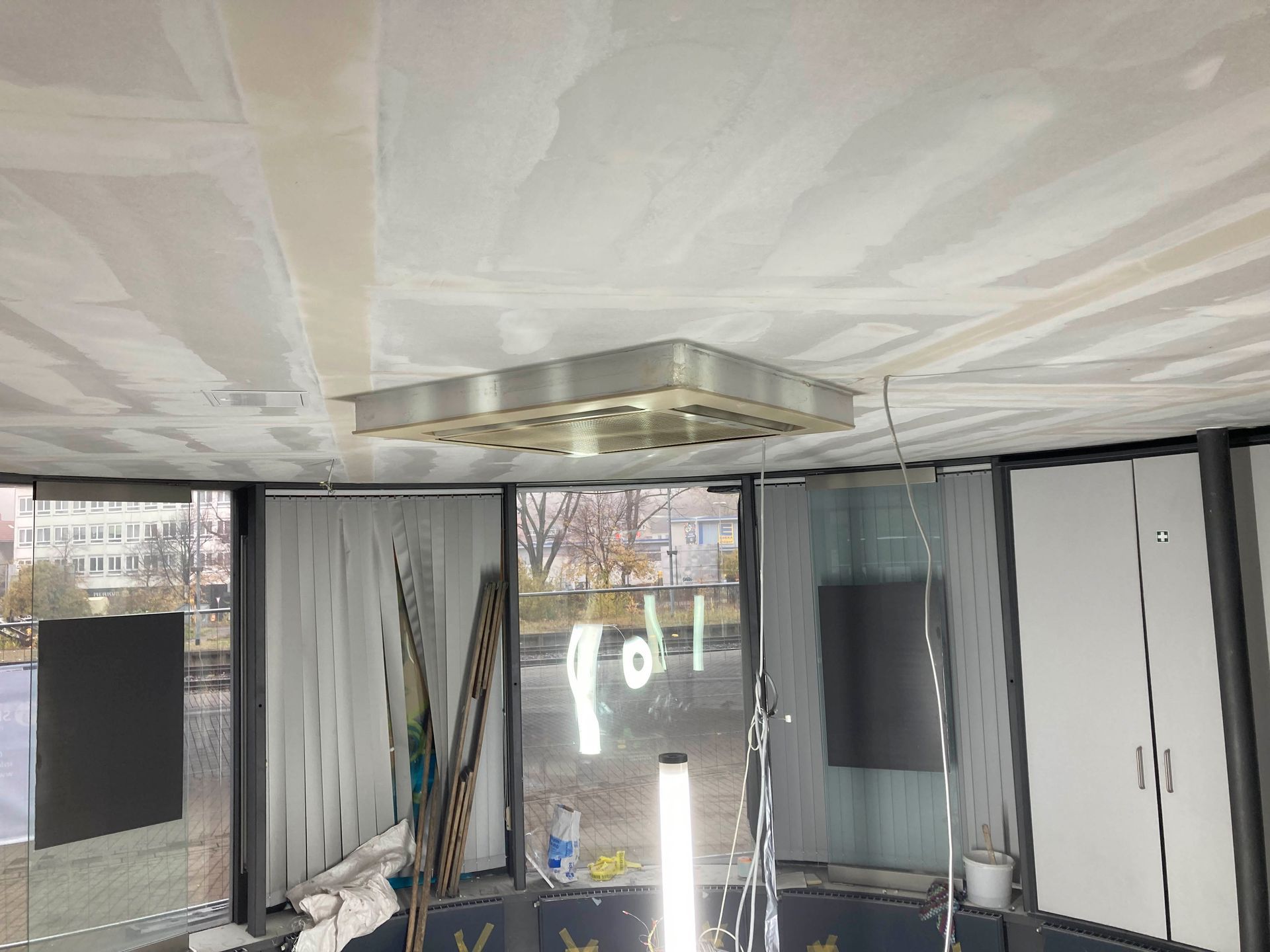 Deckenleuchte in einem Raum mit Fenster, teilweise mit Trockenbauwänden.