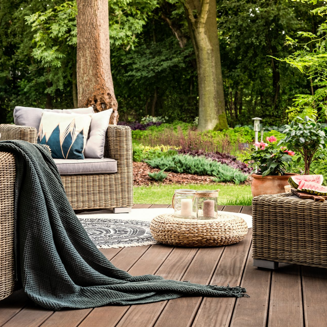 Espace détente extérieur avec canapé et coussins sous les arbres