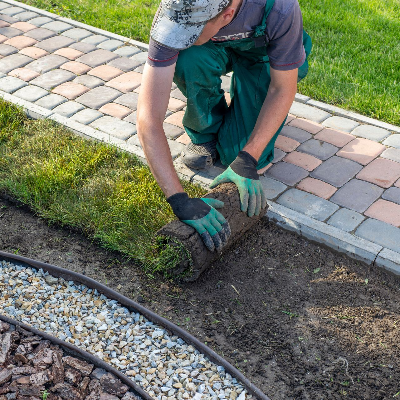Paysagiste posant des bordures en brique pour un aménagement de jardin