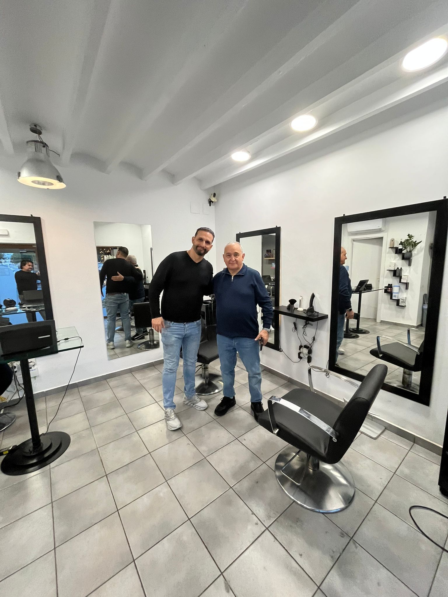 Dos hombres están parados uno al lado del otro en una barbería.