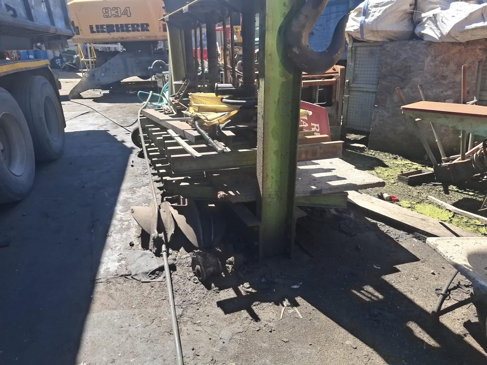 Un trabajador limpia el suelo de acero inoxidable de una fábrica con ropa y guantes de protección.