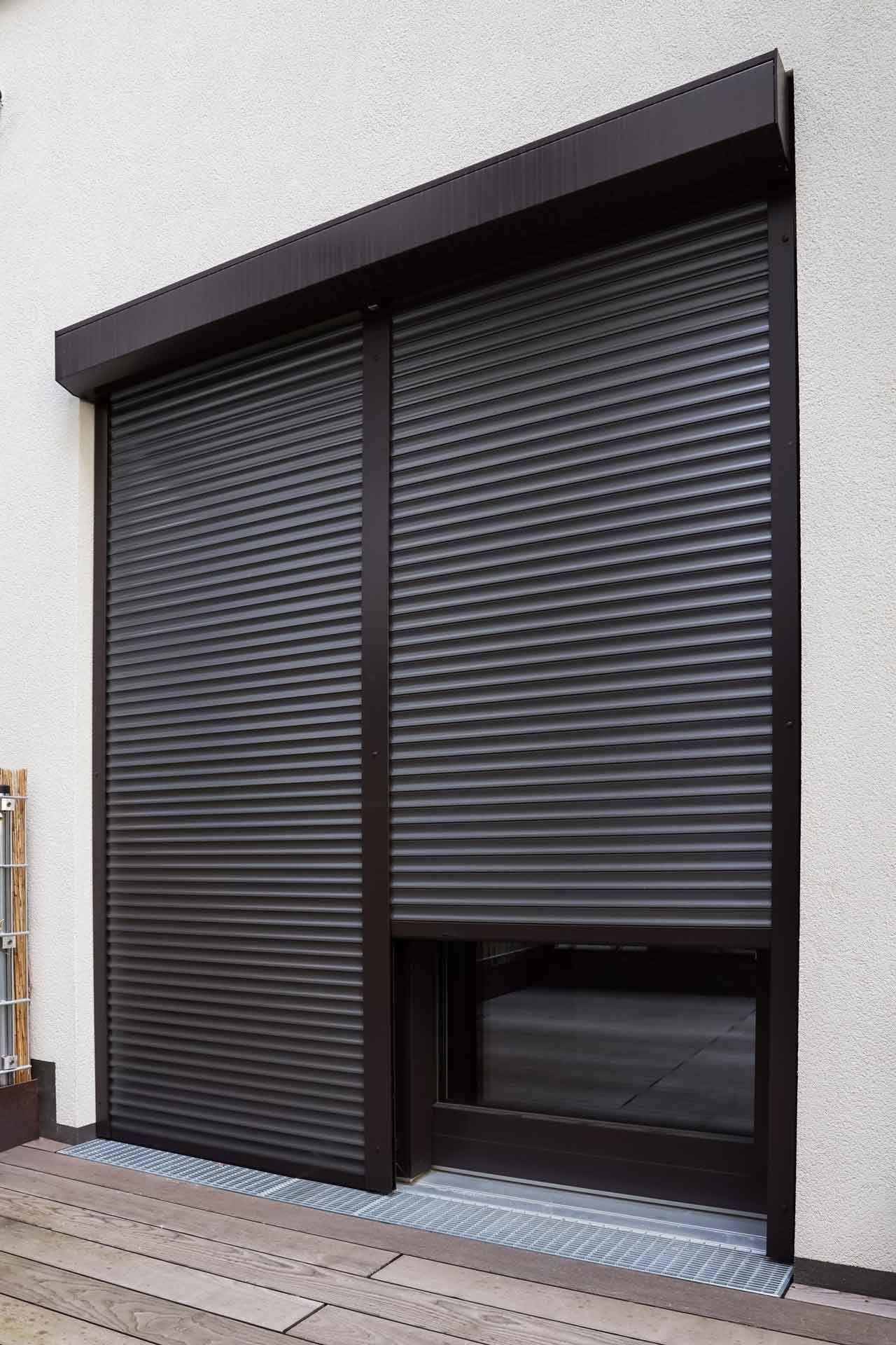 Volets roulants noirs obstruant une porte-fenêtre