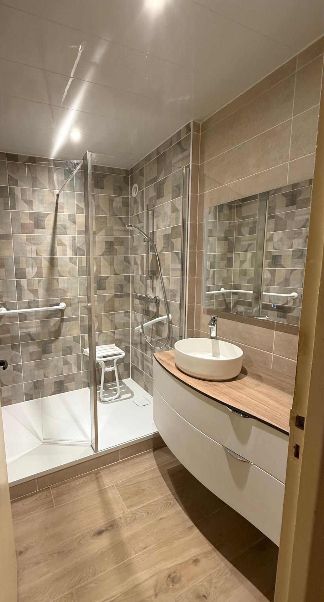 Salle de bain moderne avec douche à l'italienne, meuble de lavabo, carrelage aux tons neutres et parquet en bois clair.