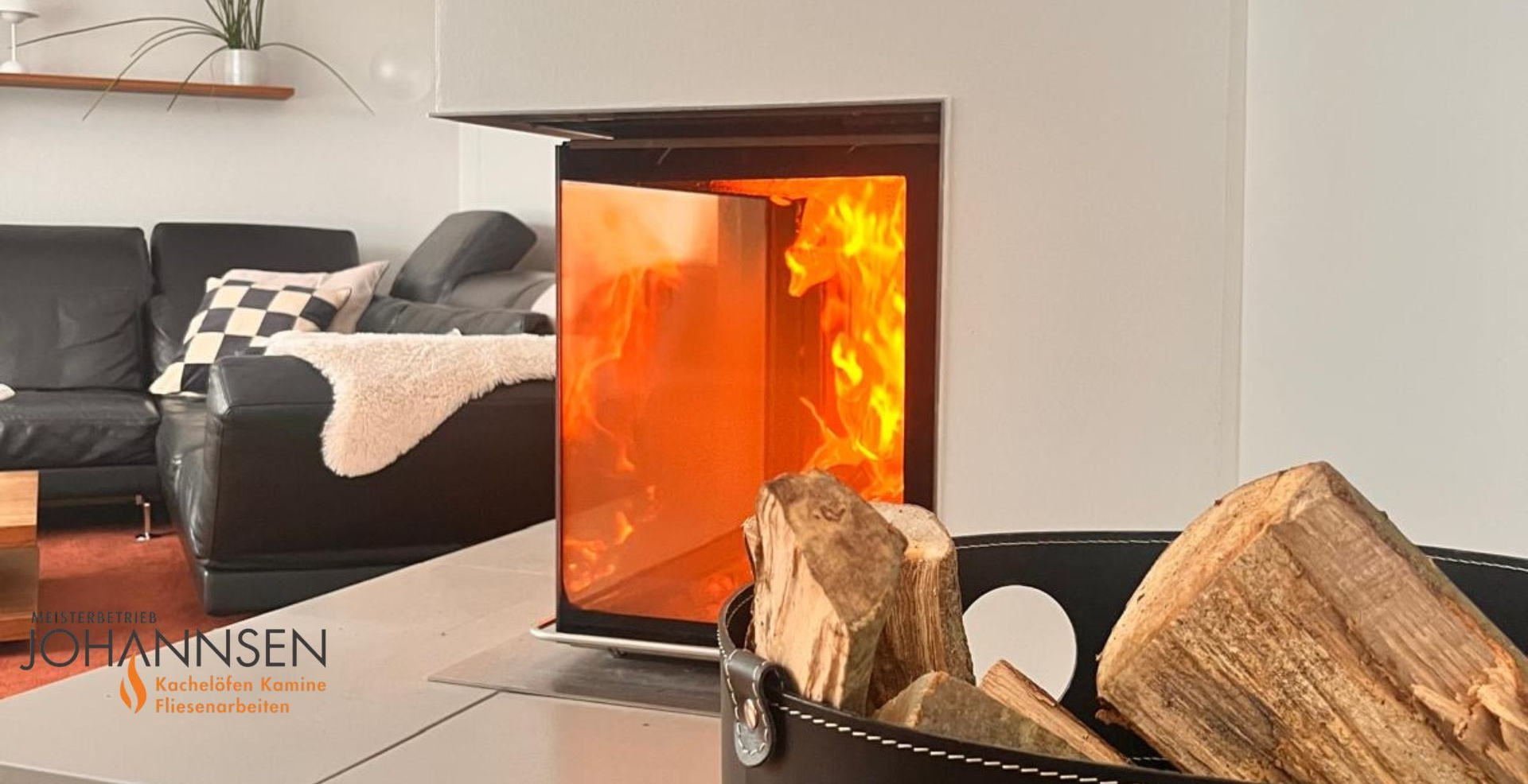Moderner Kamin mit Flammeneffekt in einem weiß-grauen Wohnzimmer mit schwarzem Ledersofa.