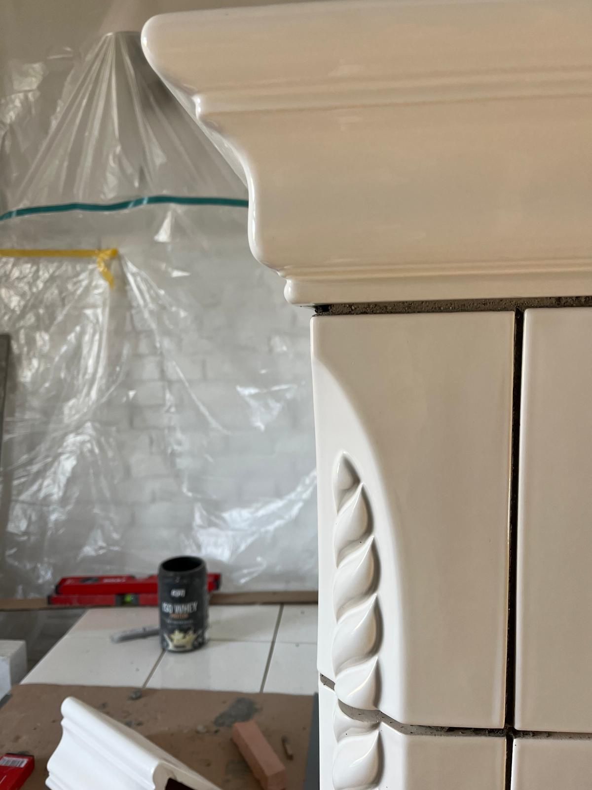 Weiß lackierter Schrank mit dekorativen Blattschnitzereien während einer Renovierung.