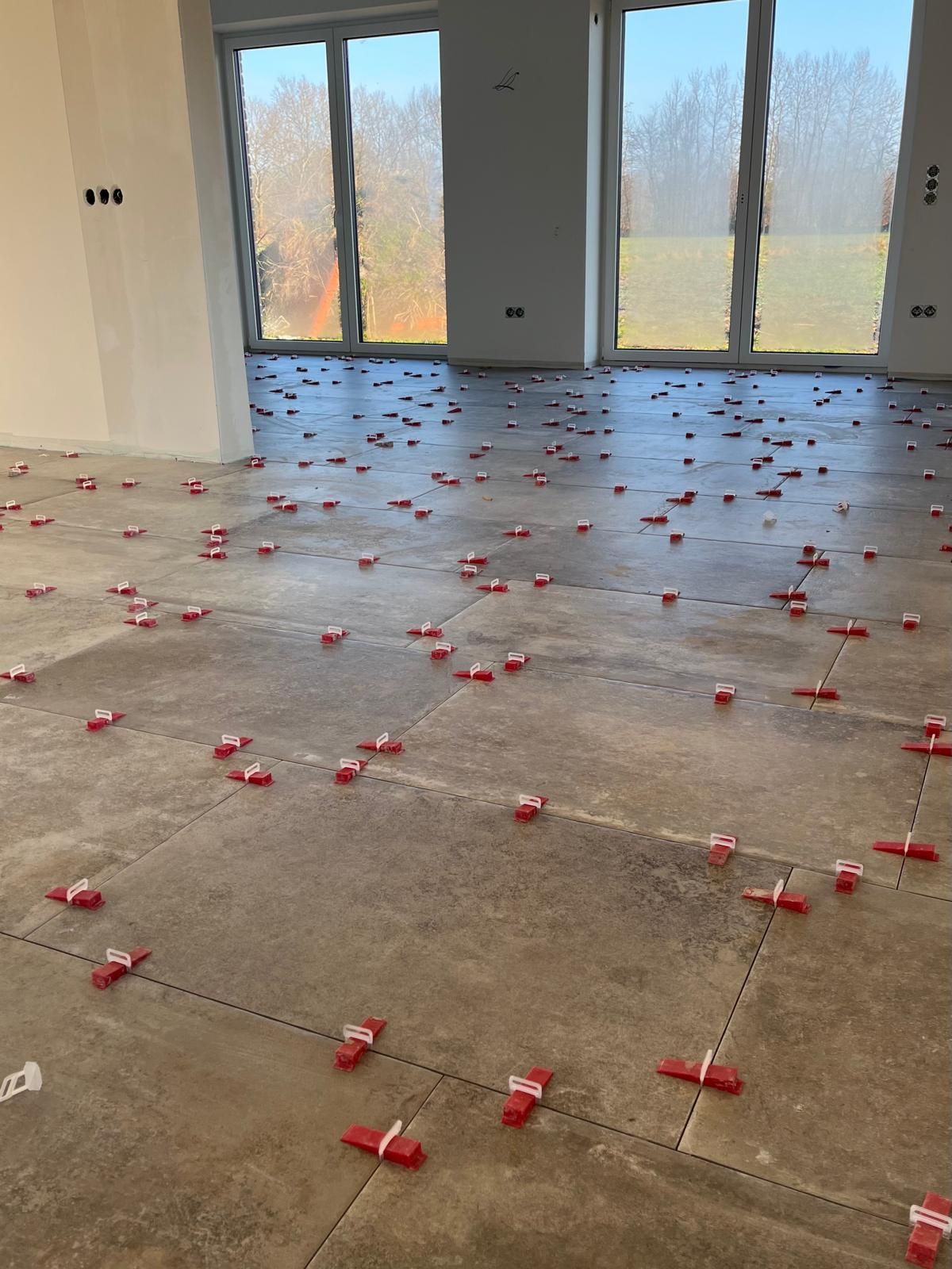 Ein moderner, weiß gefliester Kamin mit einem hell lodernden, schwarz umrahmten Feuer in einem Raum mit Kücheninsel.