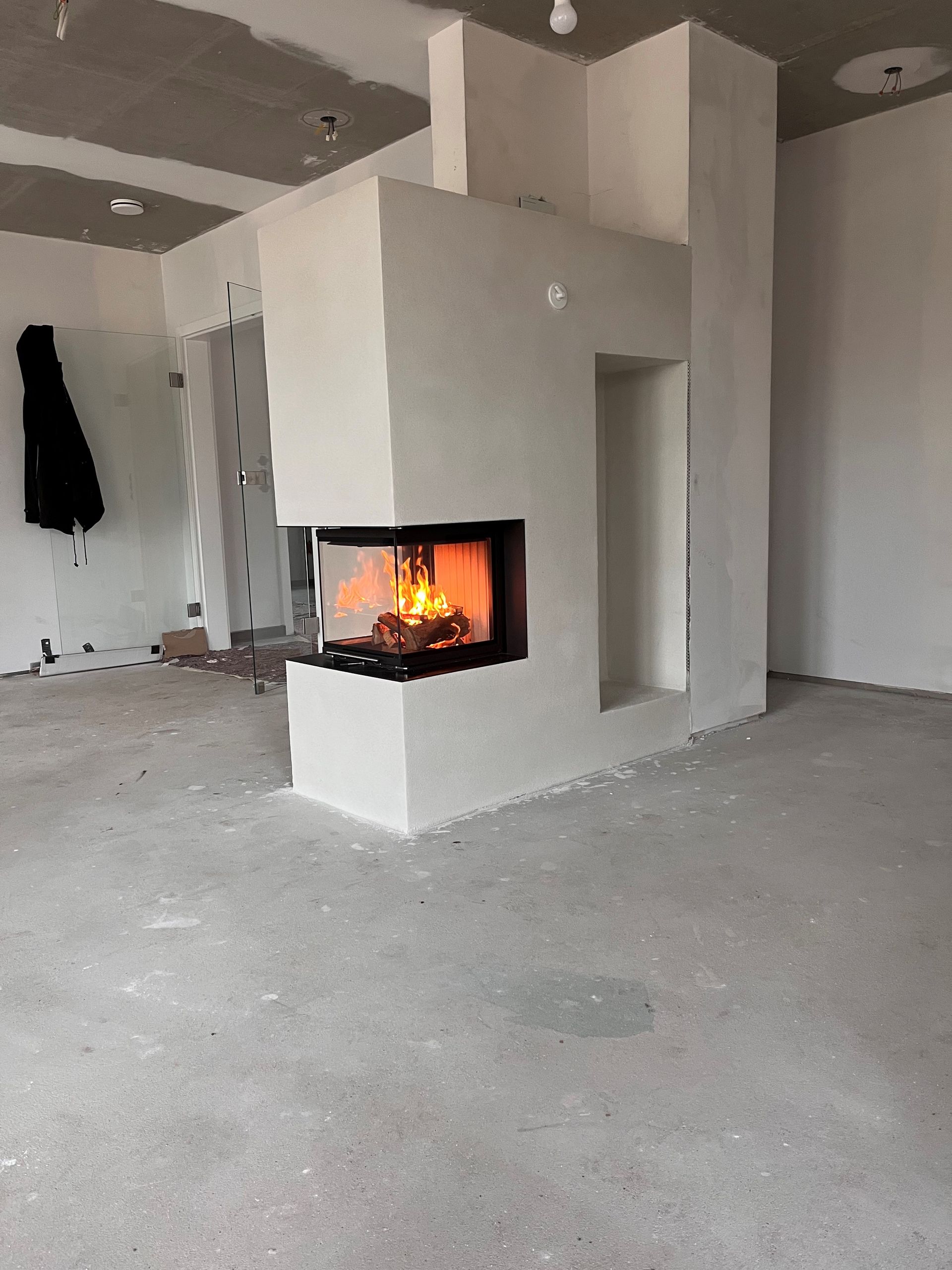 ein leerer Raum mit einem Kamin in der Ecke