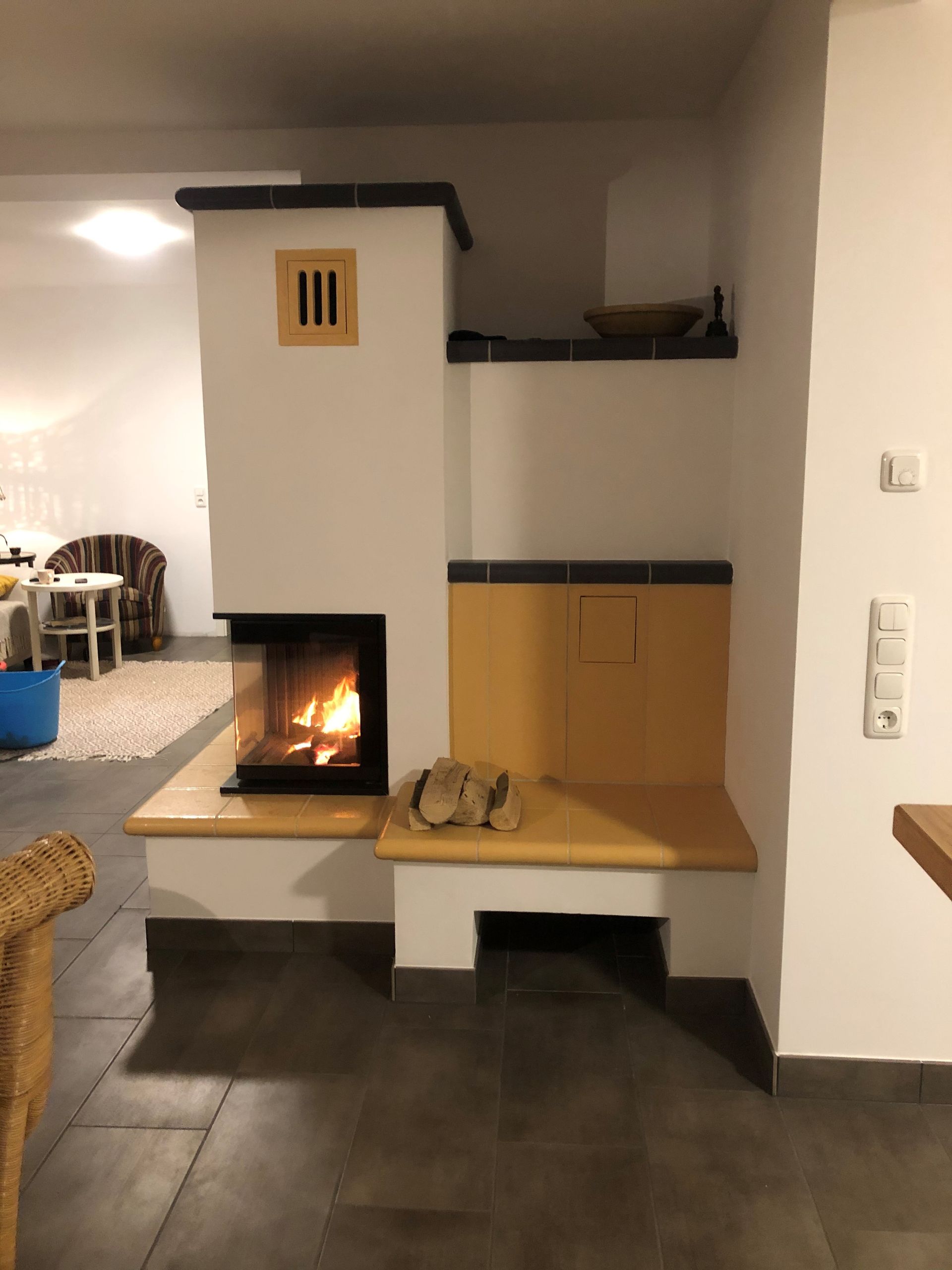 ein Wohnzimmer mit Kamin und Korbstuhl