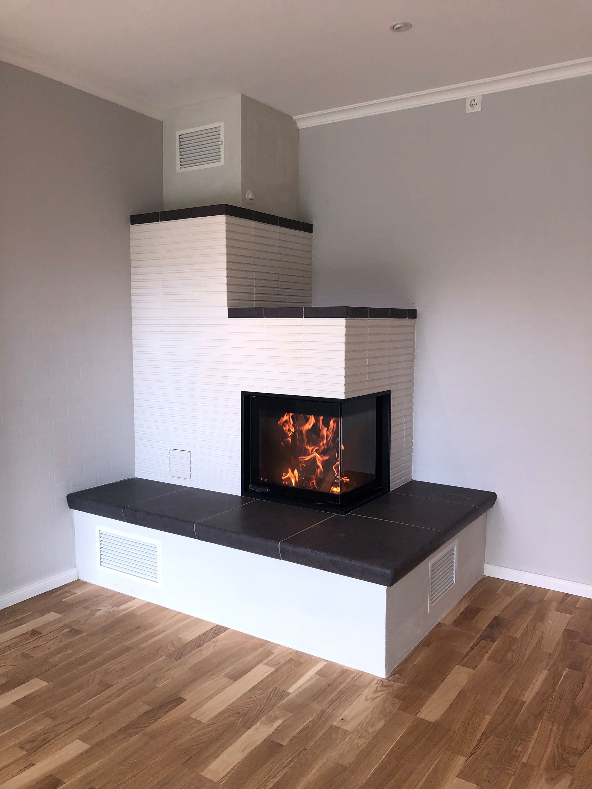 In der Ecke des Zimmers befindet sich ein Kamin.