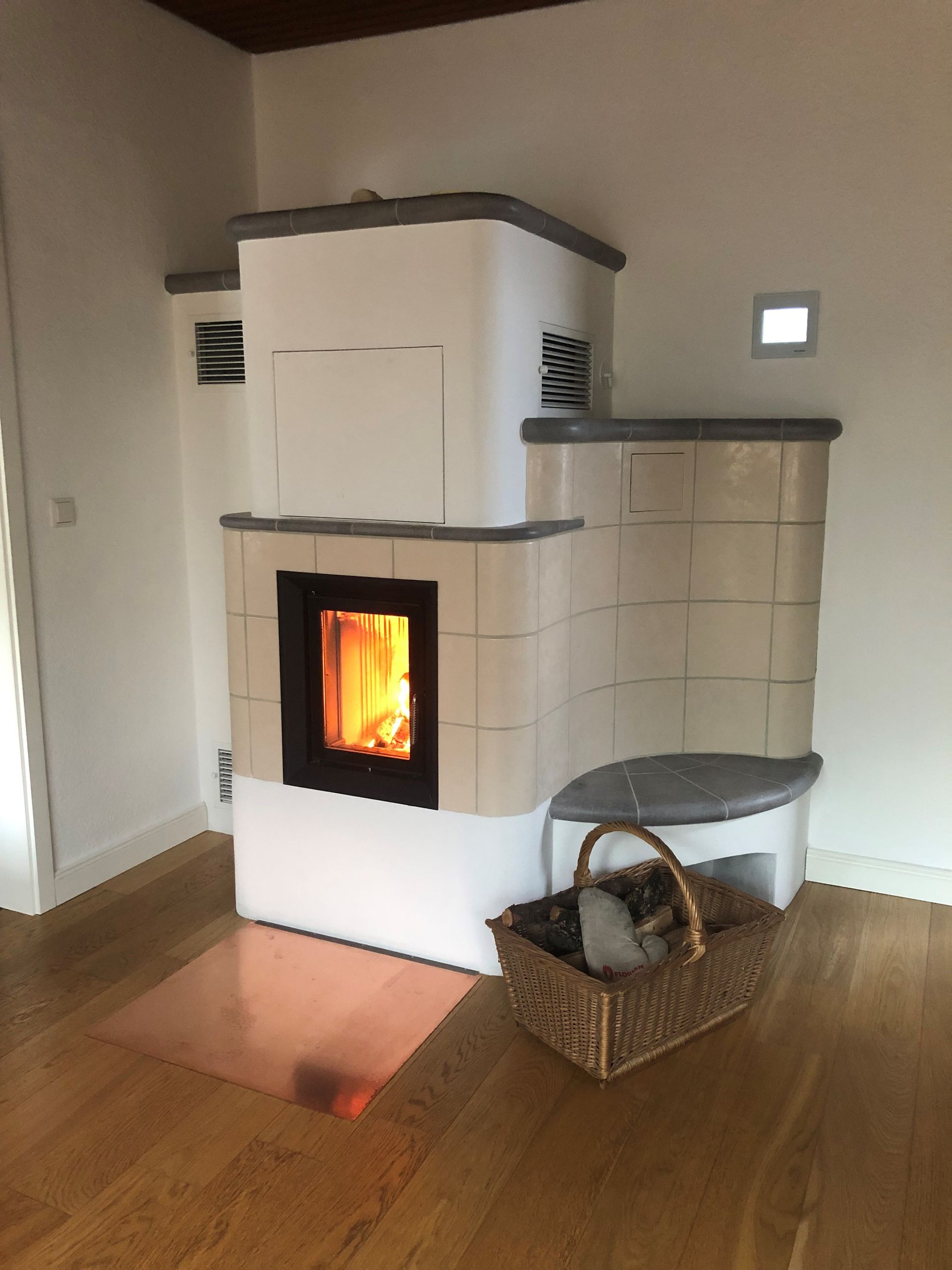 ein Kamin mit einem Korb voller Holzscheite davor