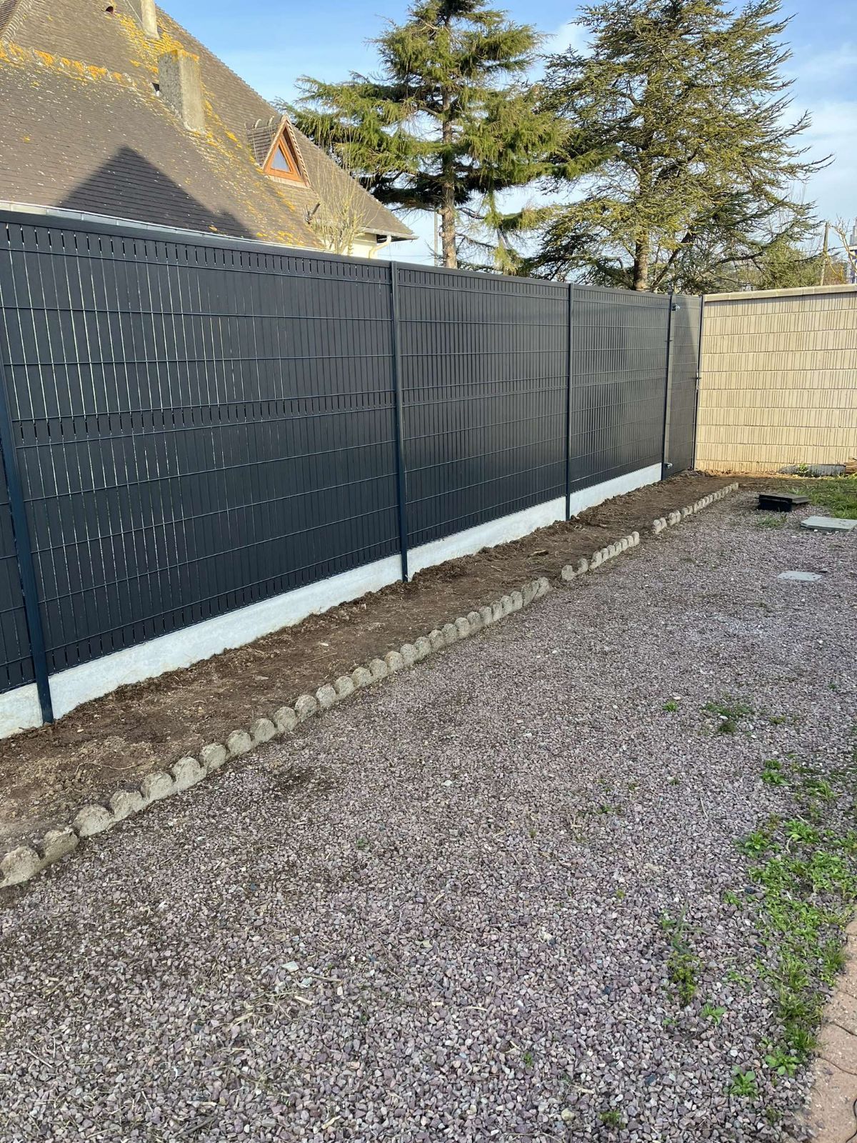 Clôture opaque le long d'un chemin d'accès