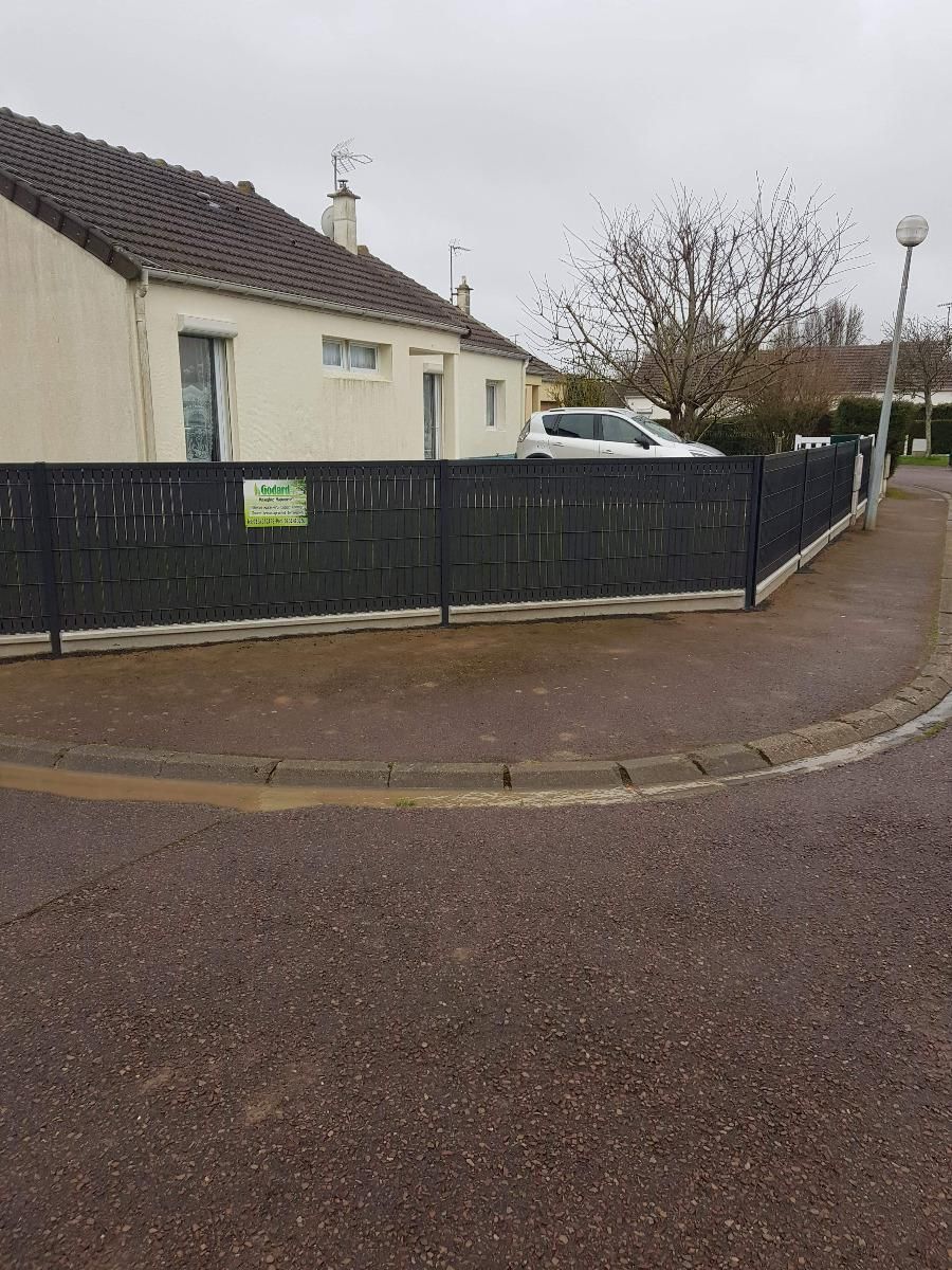 Clôture noire avec une affiche de l'entreprise