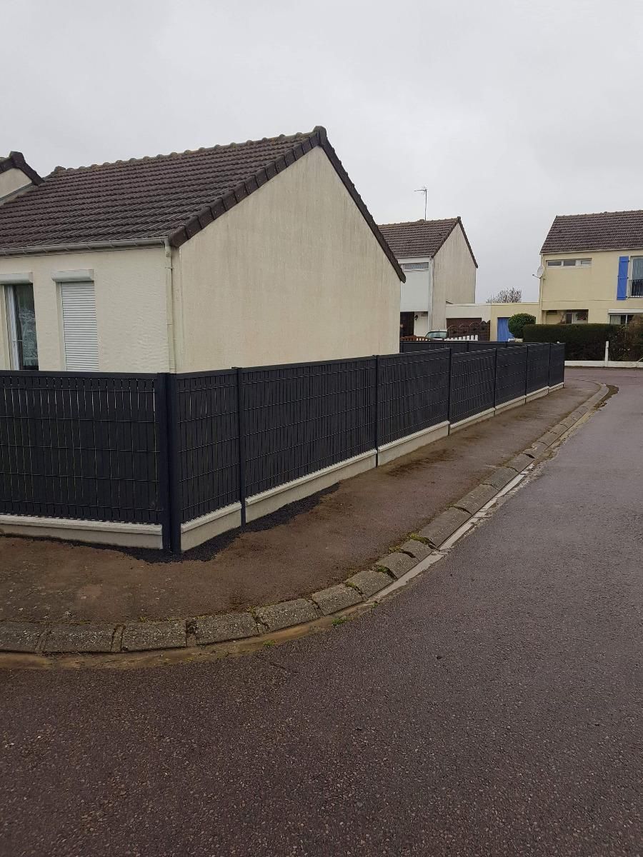 Clôture noire derrière un trottoir