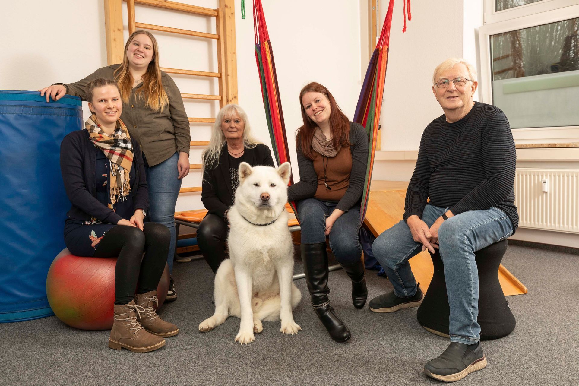 Eine Gruppe von Menschen posiert für ein Foto mit einem Hund.