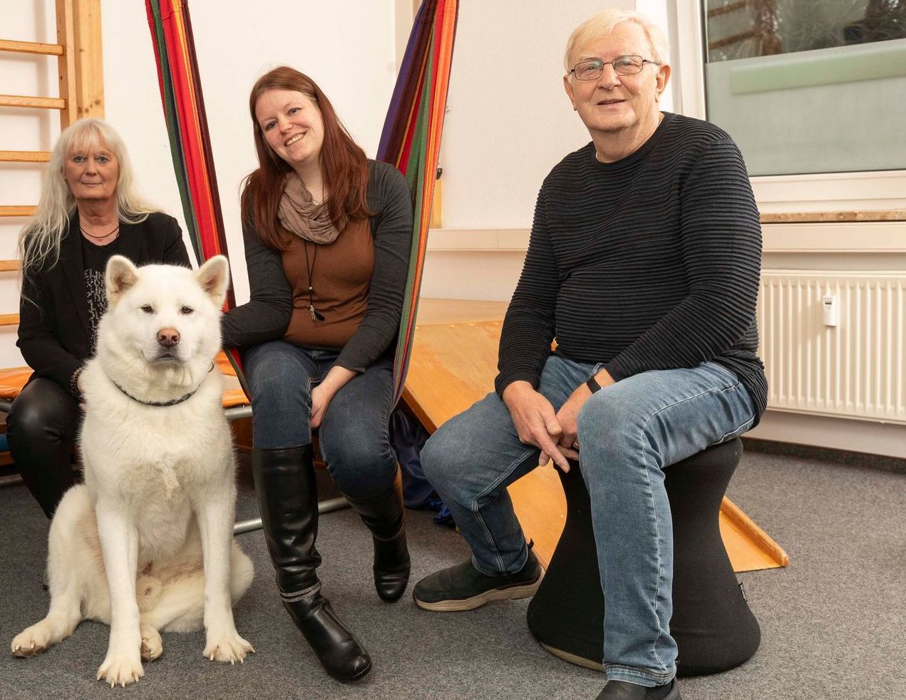 Eine Gruppe von Menschen posiert für ein Foto mit einem Hund.