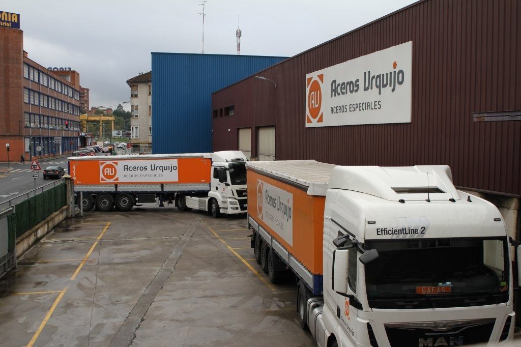 Varios camiones están estacionados frente a un edificio que dice Alonso Urquijo