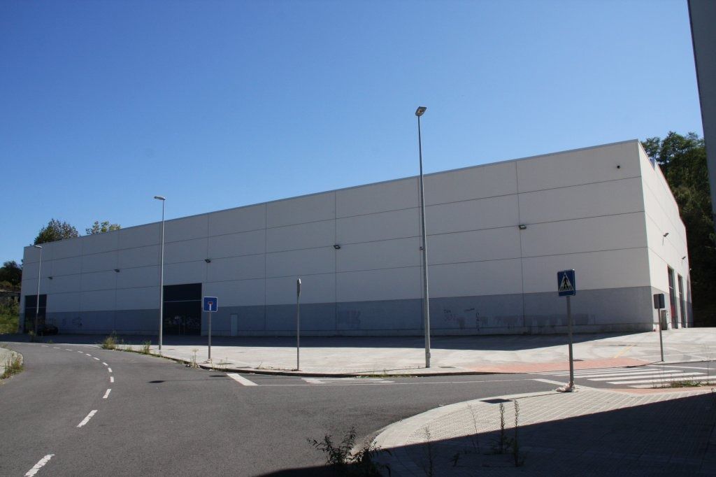 Un gran edificio blanco se encuentra en la esquina de una calle.