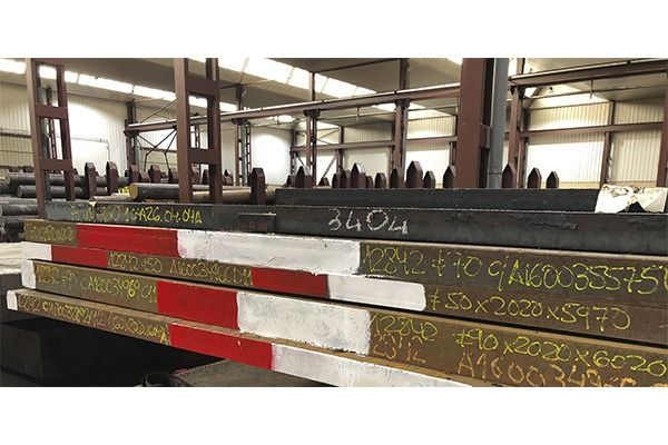 Un montón de piezas de metal están apiladas una encima de otra en un almacén.