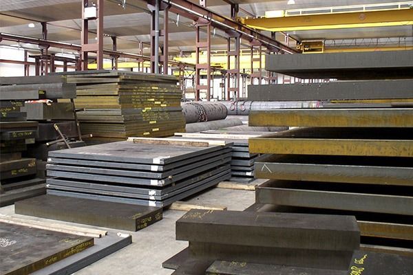 Un almacén lleno de muchas láminas de metal y algunos trozos de madera.