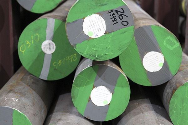 Un montón de varillas de metal verdes y grises están apiladas una encima de otra.