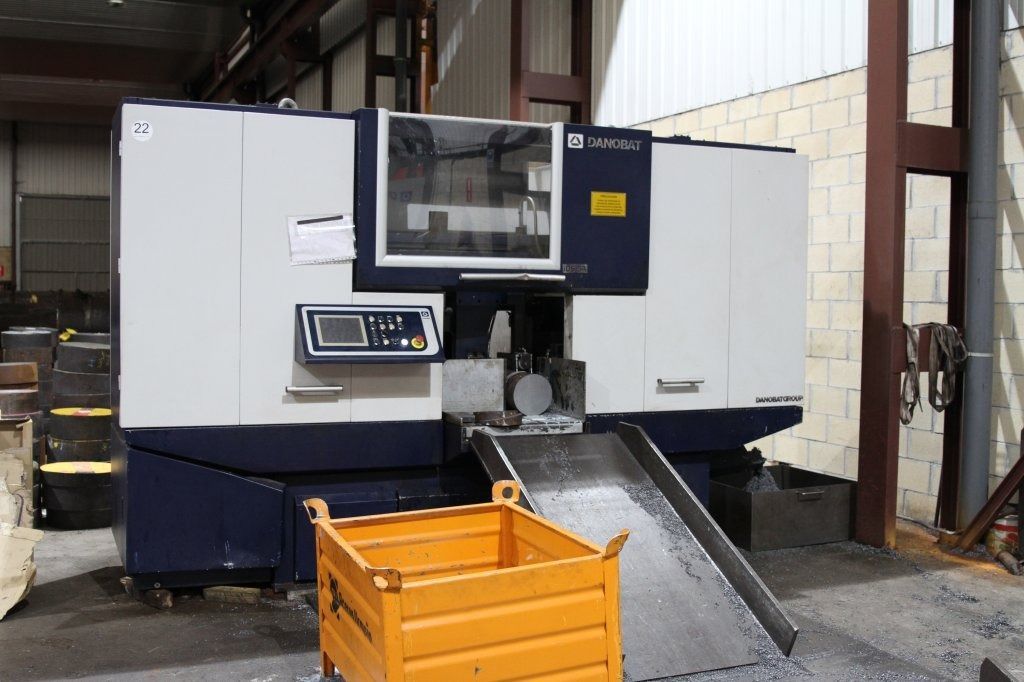 Una máquina está en un almacén al lado de una caja amarilla.