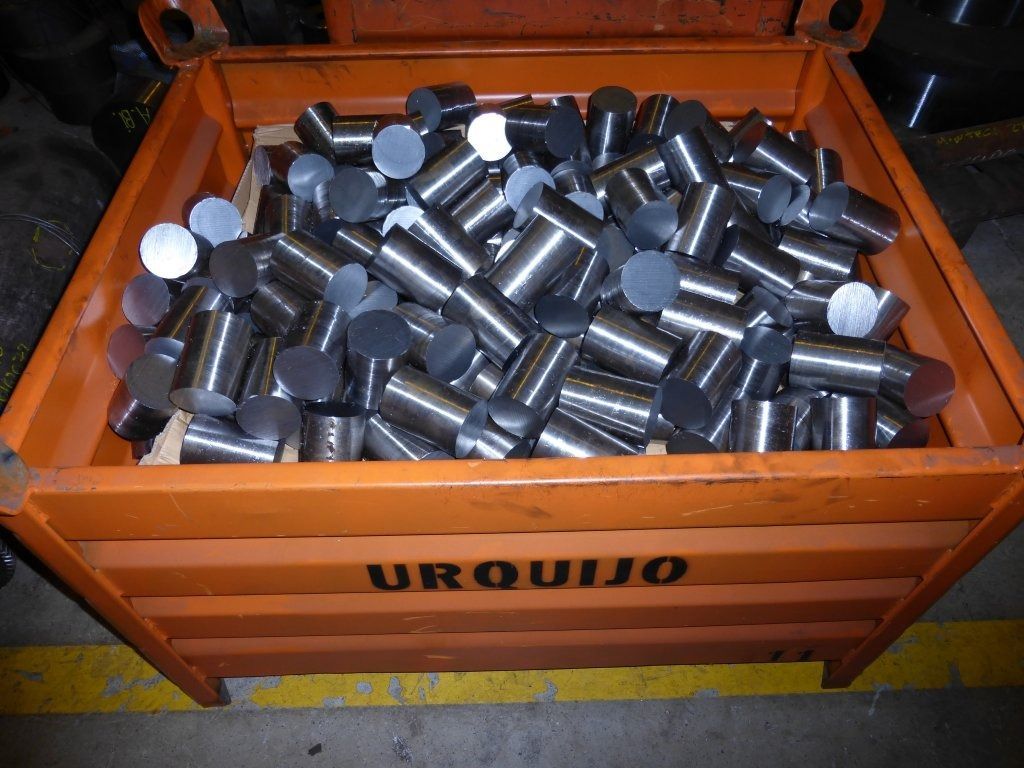 Una caja de madera llena de cilindros de metal está etiquetada como uroquijo.