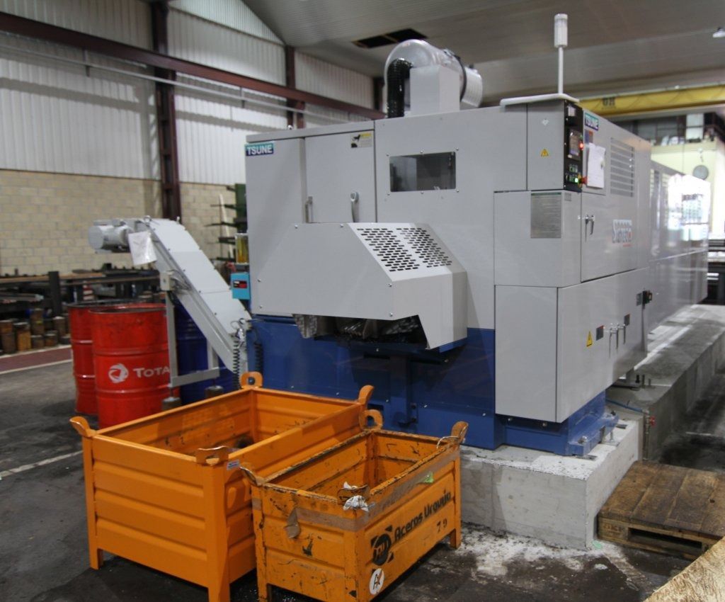 Una máquina está sentada en una fábrica al lado de un barril de petróleo.