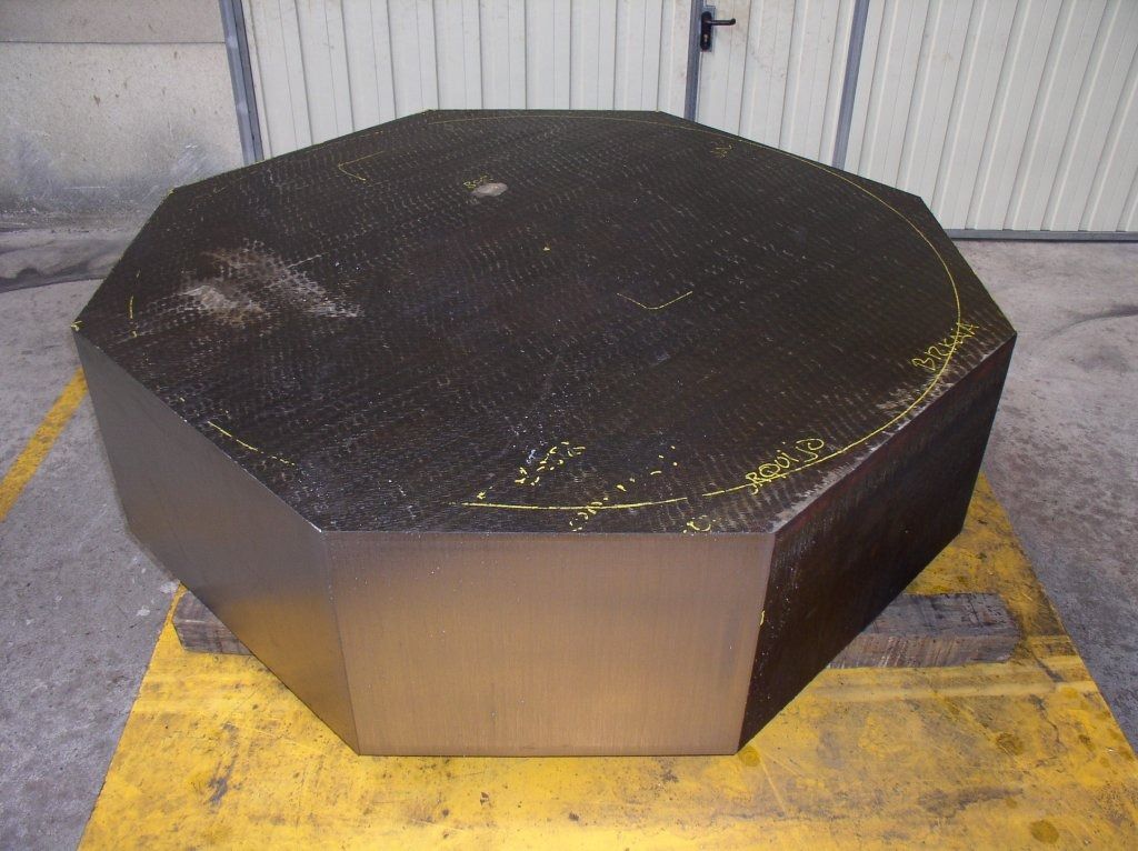 Un objeto negro con forma de octágono está sobre una paleta amarilla.