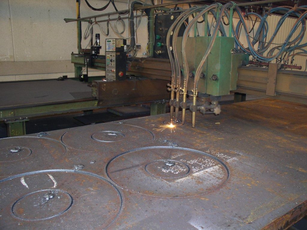 Una máquina está cortando un trozo grande de metal.