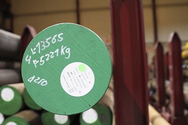 Un cartel verde está encima de una pila de tubos de metal.