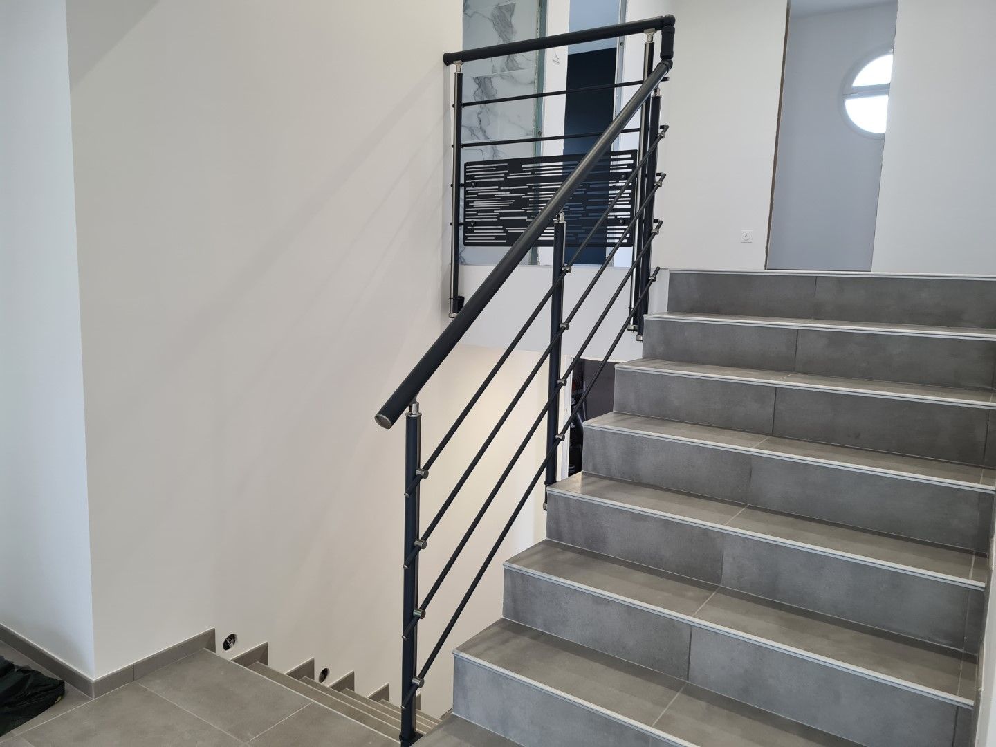 Un garde-corps d'escalier avec main courante et traverses à formes rondes