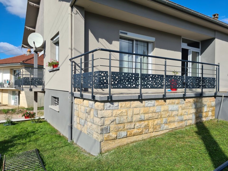 Une terrasse de maison avec une rambarde