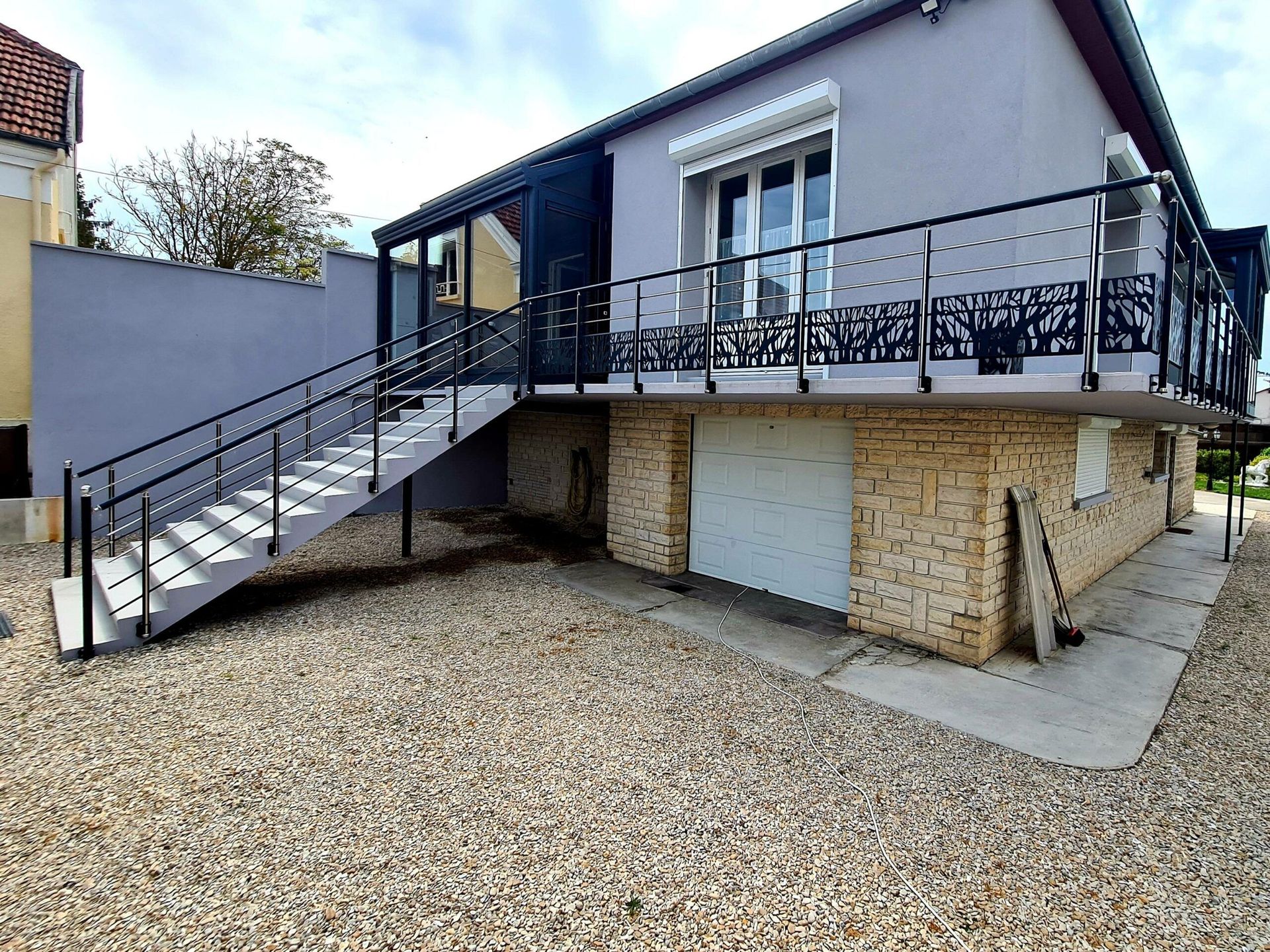 Maison avec terrasse et escaliers sécurisés par une rambarde