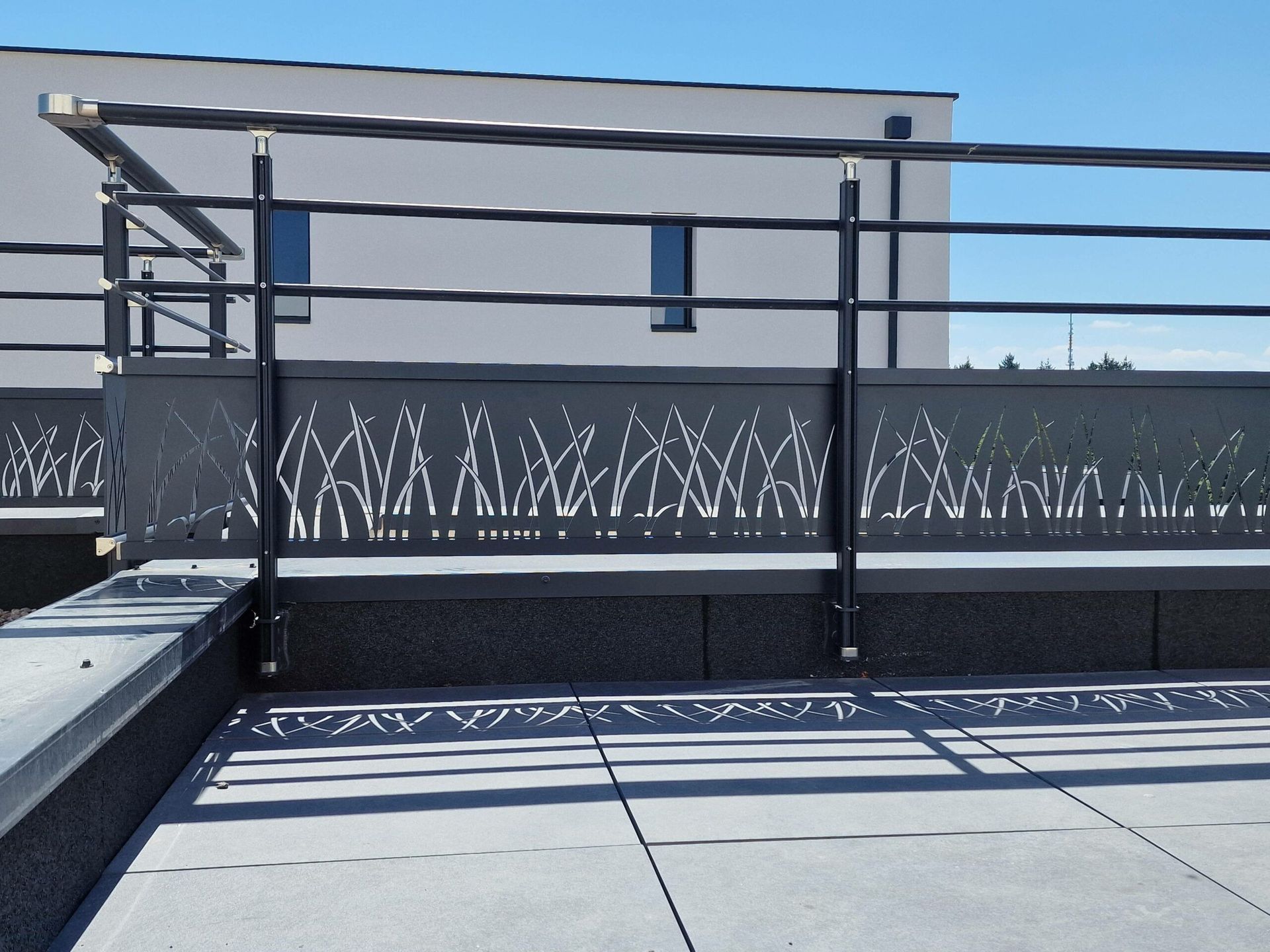 Un garde-corps avec main courante et traverses à formes ovales