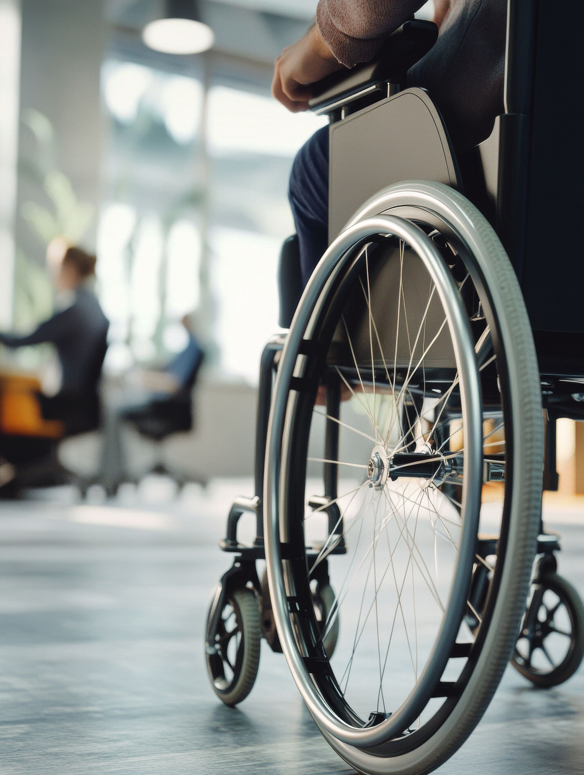 Personne en fauteuil roulant, main sur le volant. Extérieur, arrière-plan flou.