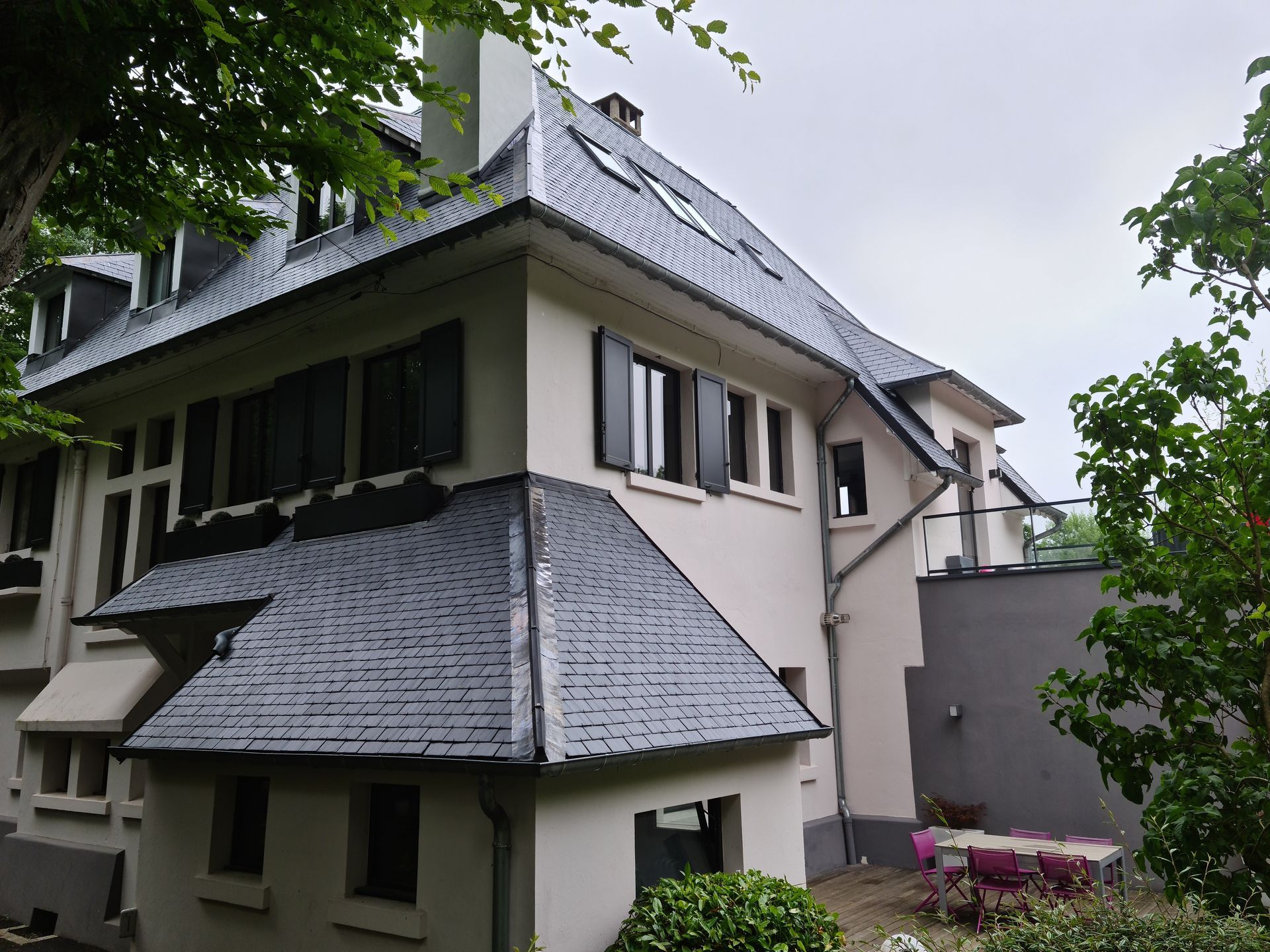 Maison blanche avec des toitures en ardoises