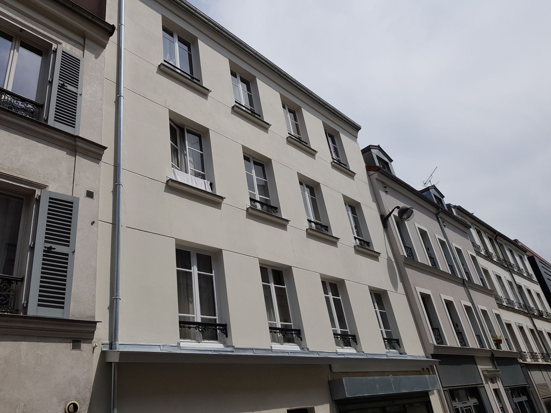 Façade d'immeuble blanche avec des appuis fenêtres en zinc