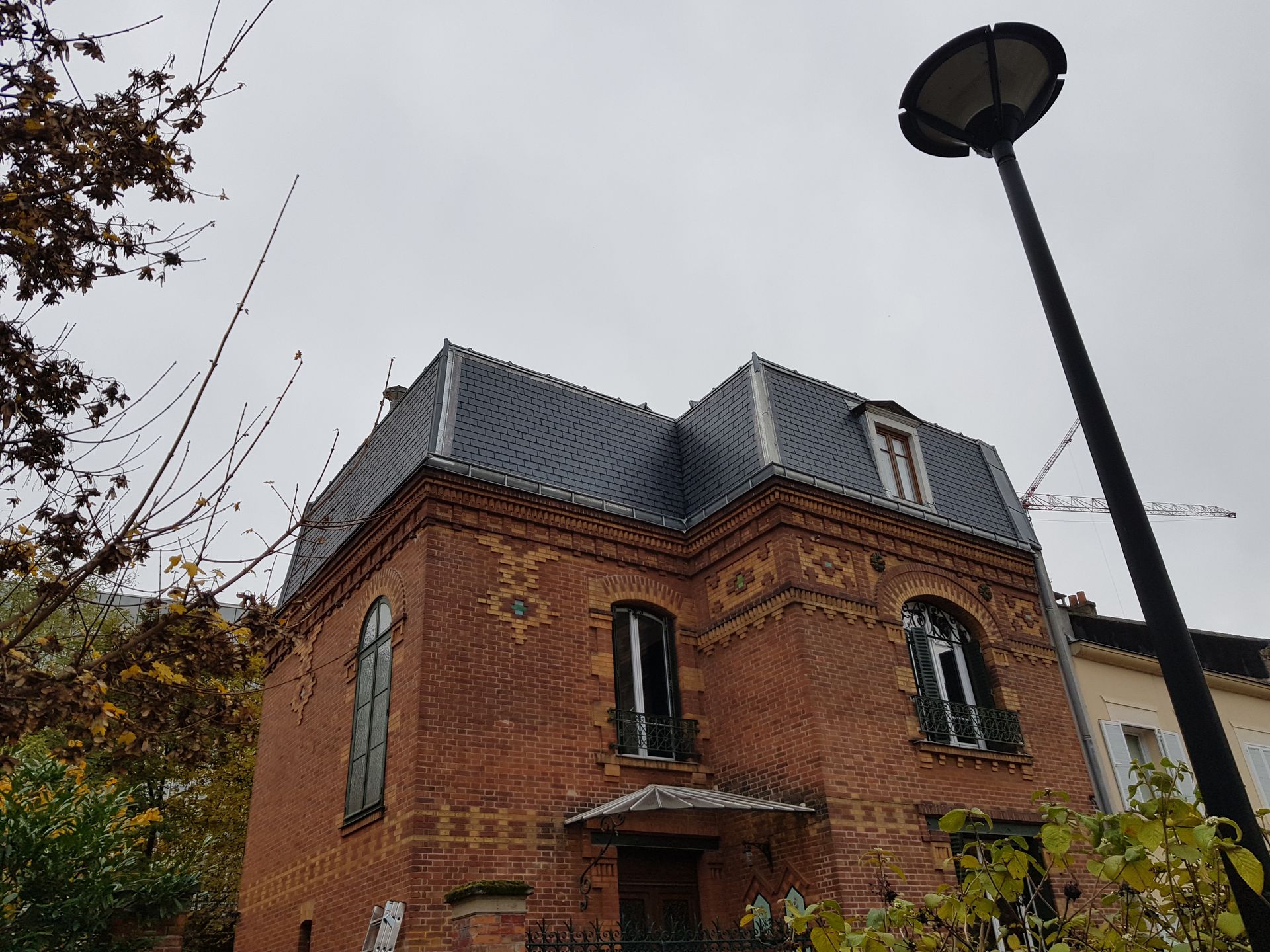 Maison de briques rouges avec une toiture en ardoise