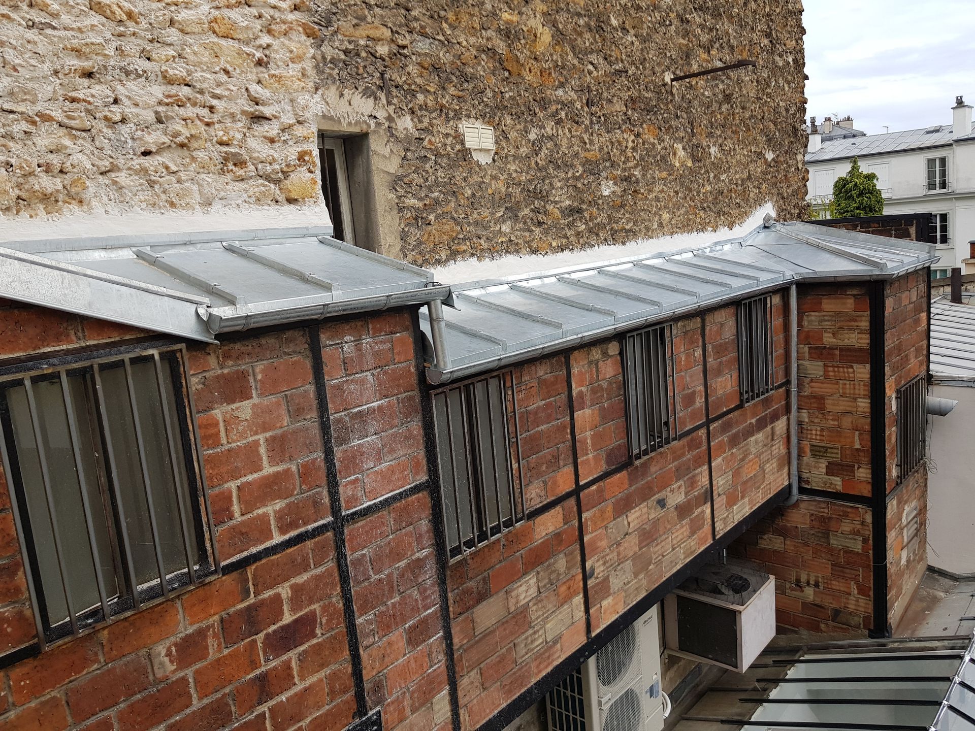 Avancées en briques rouges avec toitures en zinc