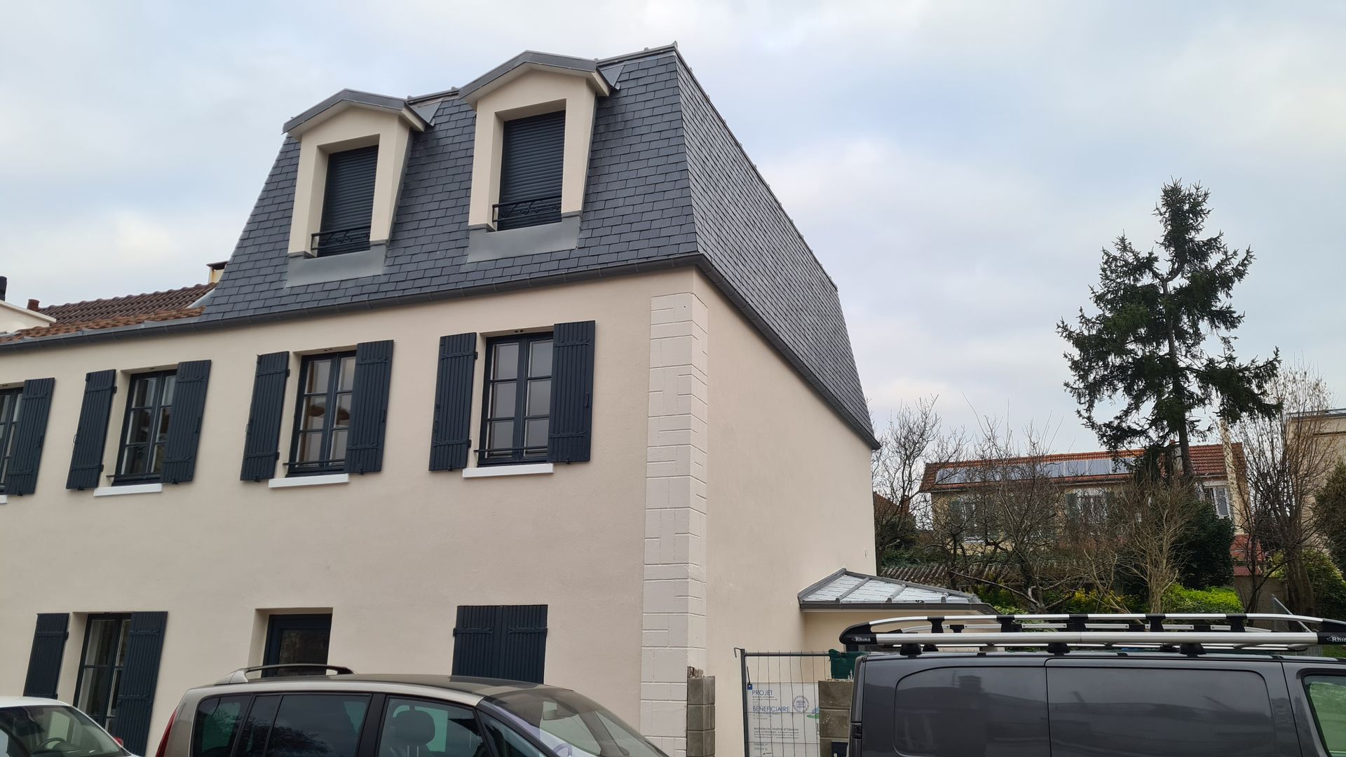 Maison blanche avec une toiture parisienne en ardoise