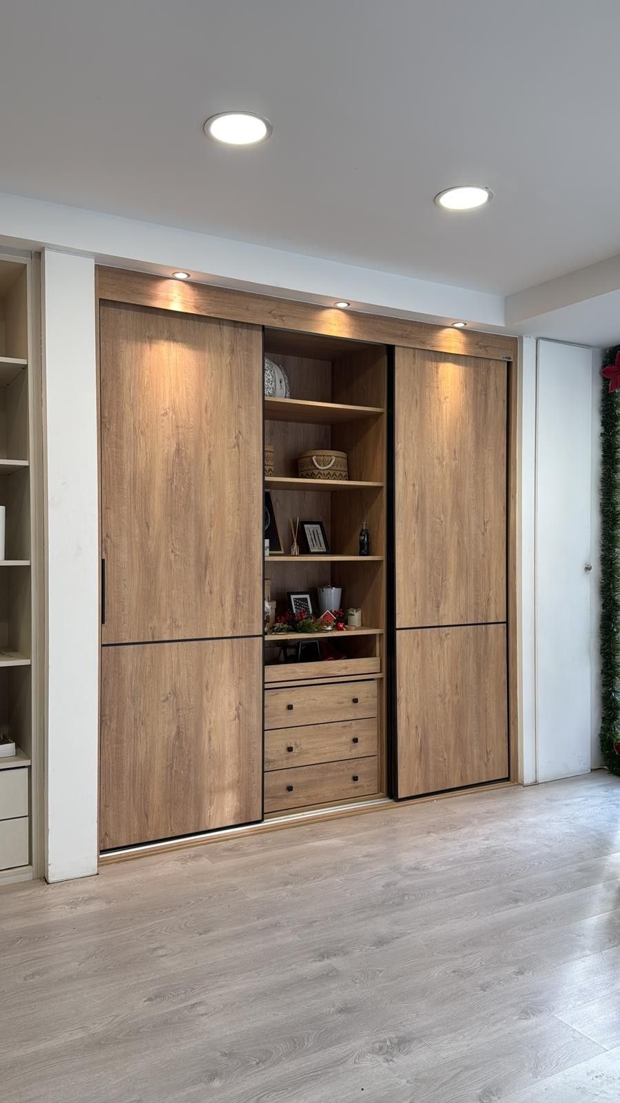 Mueble de pared de madera empotrado con estantes y armarios en una habitación moderna.