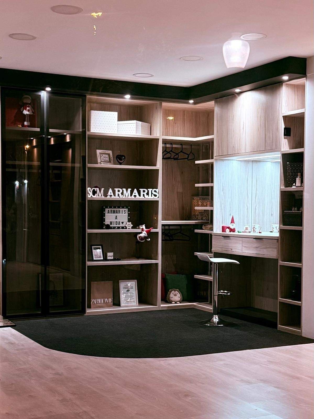 Estanterías vacías en una boutique con poca luz, con armarios de madera oscura y suelo de moqueta negra.