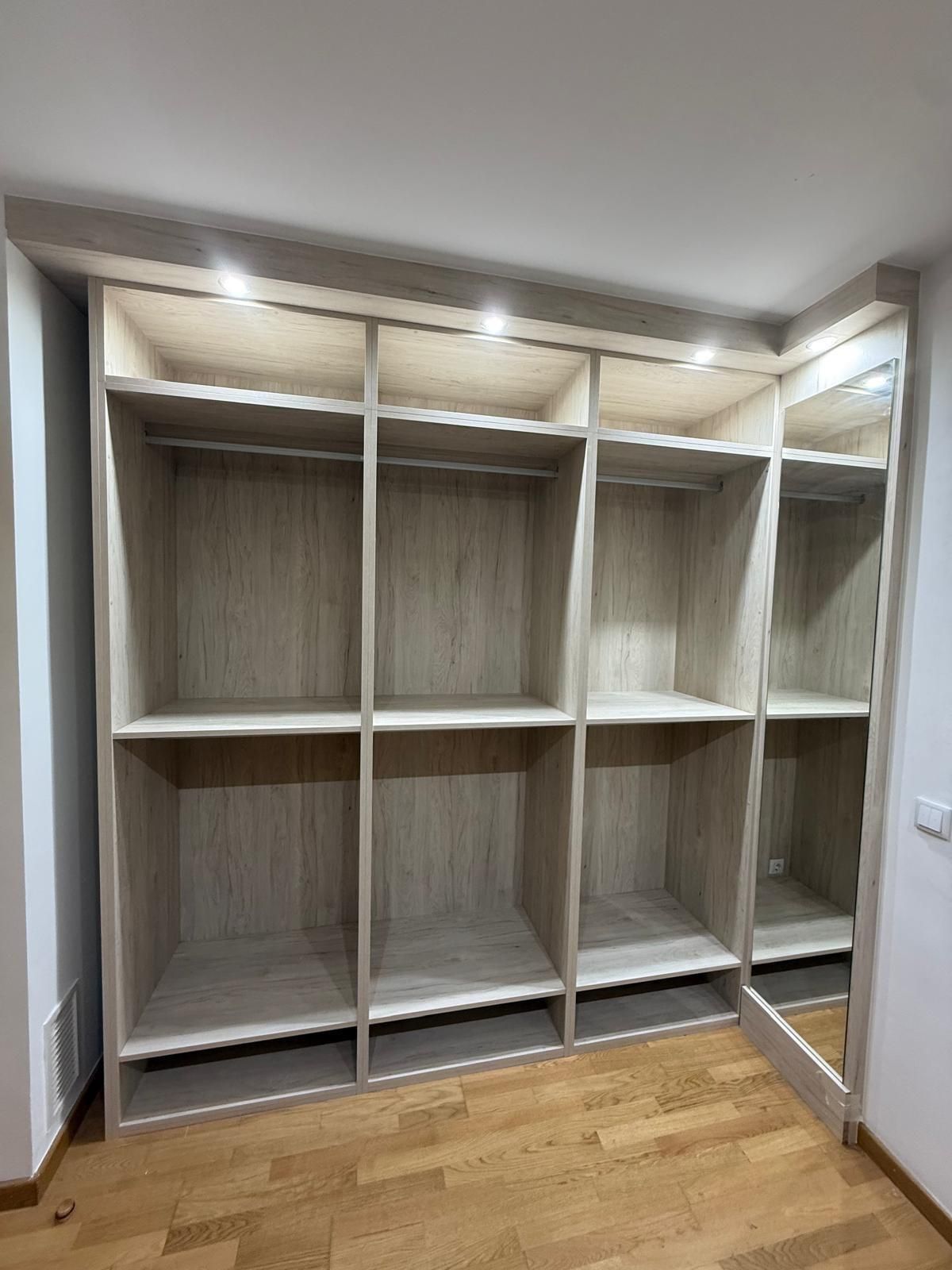 Armario empotrado blanco con estantes abiertos y revestimiento de imitación madera